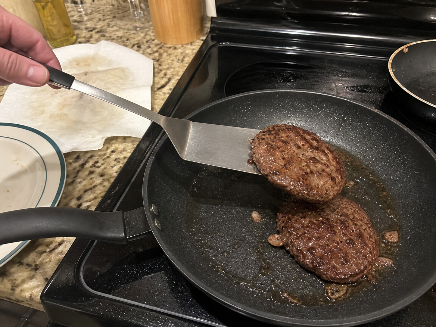 Burger patty sliding away on a flat spatula