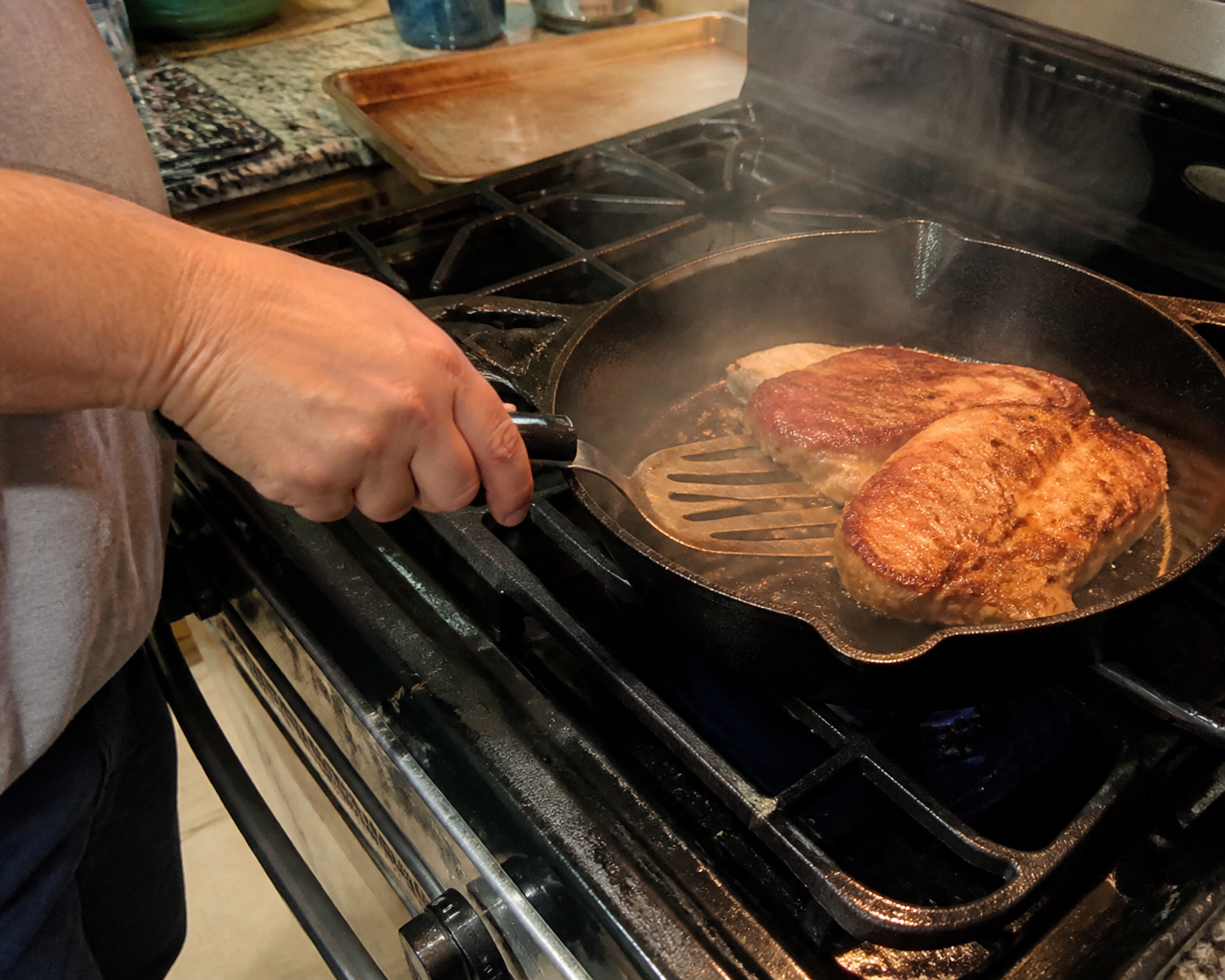 Hand close to a hot pan while cooking