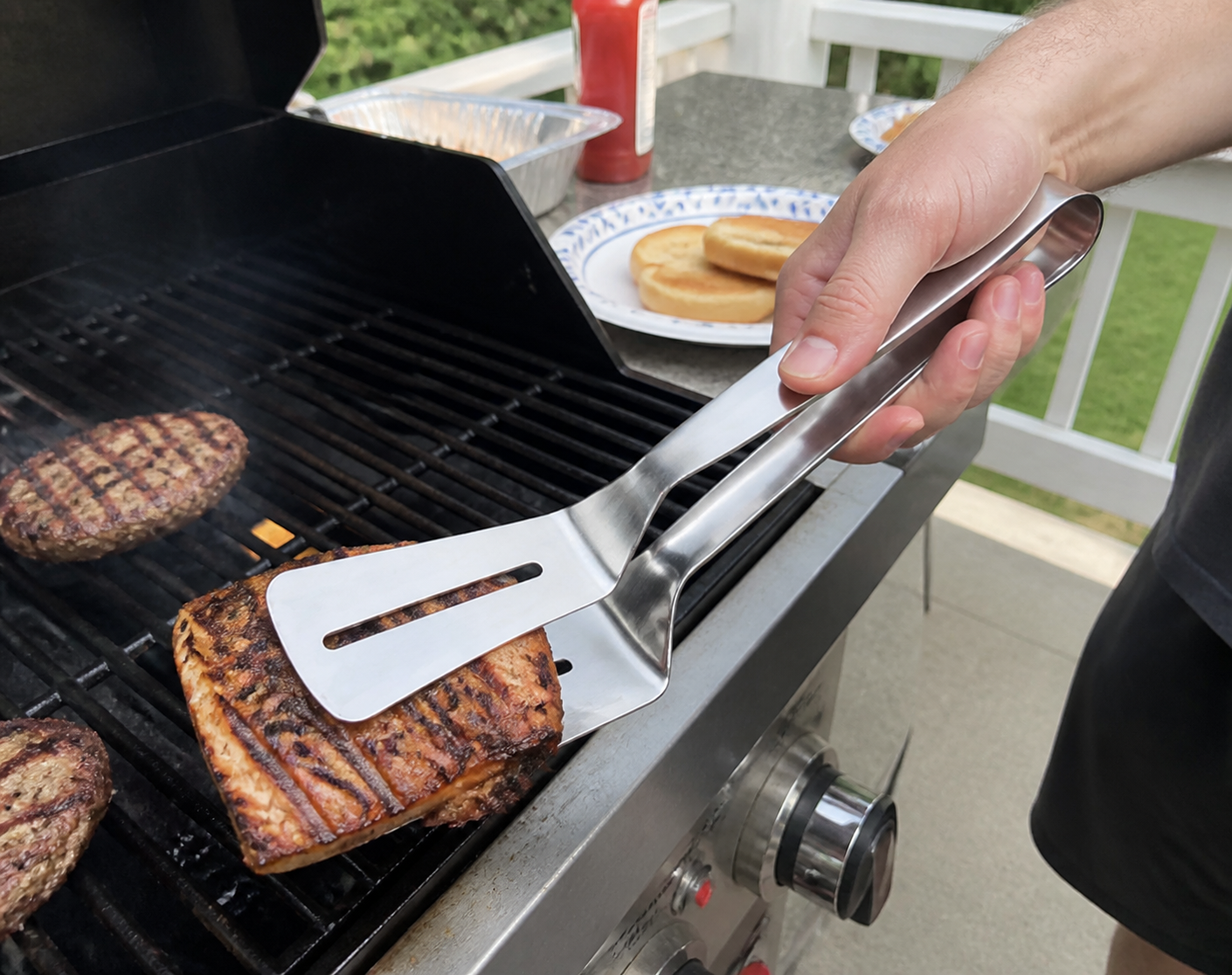 Grilled food lifted with stainless steel grill clamp spatula
