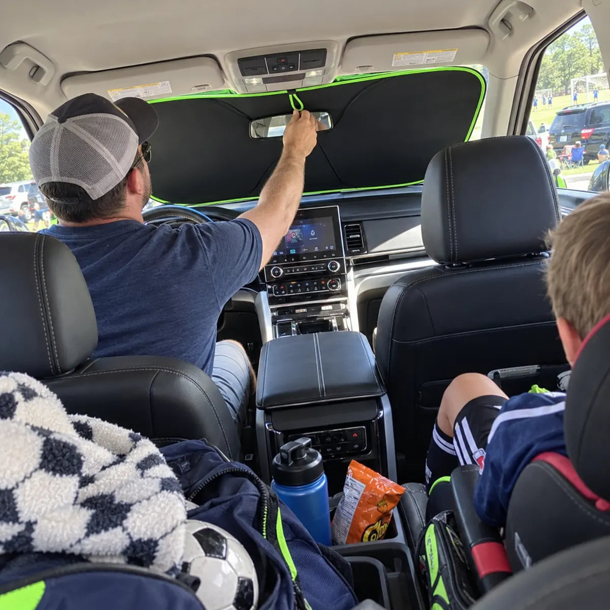 Family vehicle with windshield sun shade being installed