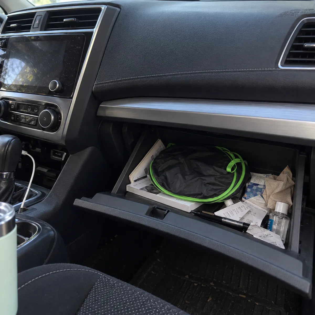 Compact foldable windshield shade stored in a glove compartment