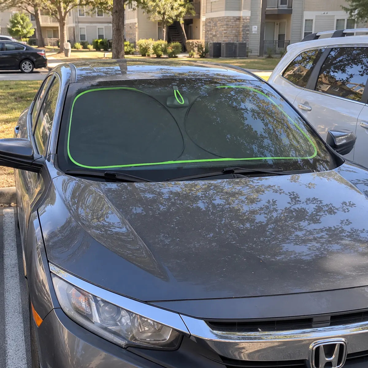 Sedan parked outside with windshield sun shade installed