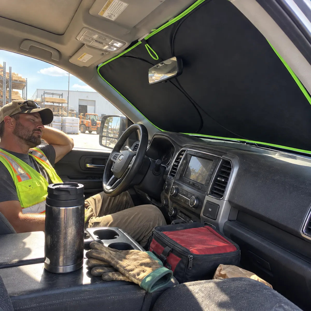 Driver resting inside a shaded work vehicle