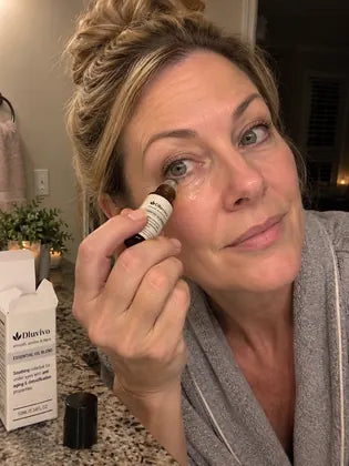 Cooling eye roller serum on a bathroom vanity with skincare products