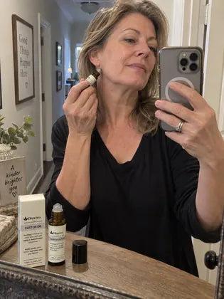 Under-eye serum roller beside concealer and a compact mirror