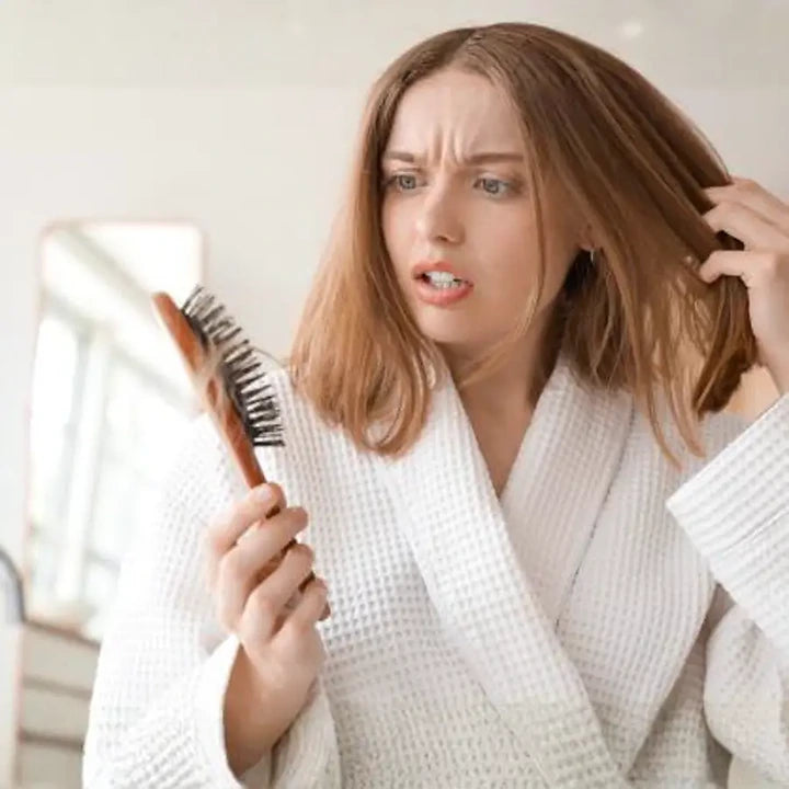 Woman holding a brush with shed hair