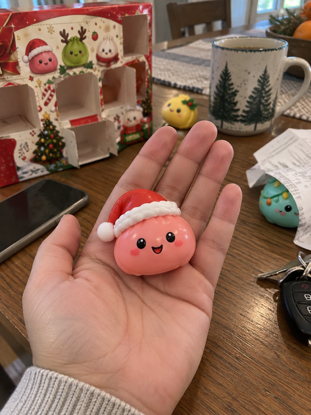 Santa-hat mini squishy resting in an adult palm for scale