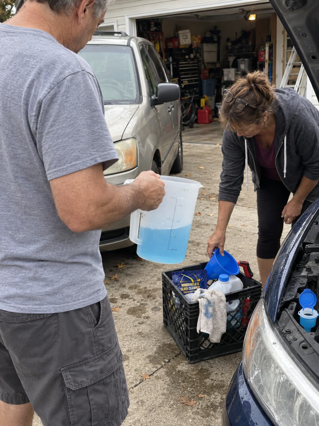 Two customers preparing washer solution for multiple cars