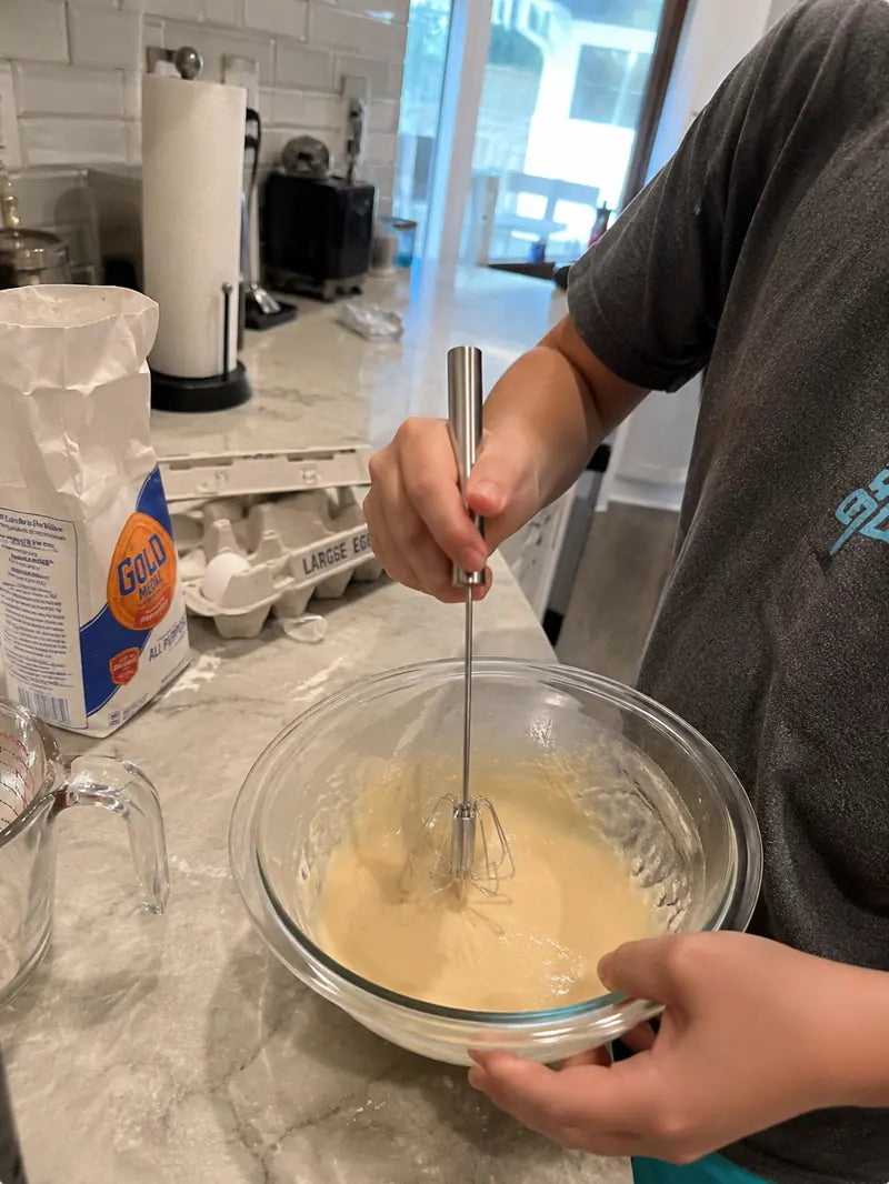 Customer using the stainless steel hand-push whisk for smooth batter