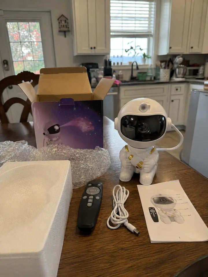 Astronaut galaxy projector unboxed on a kitchen table with accessories