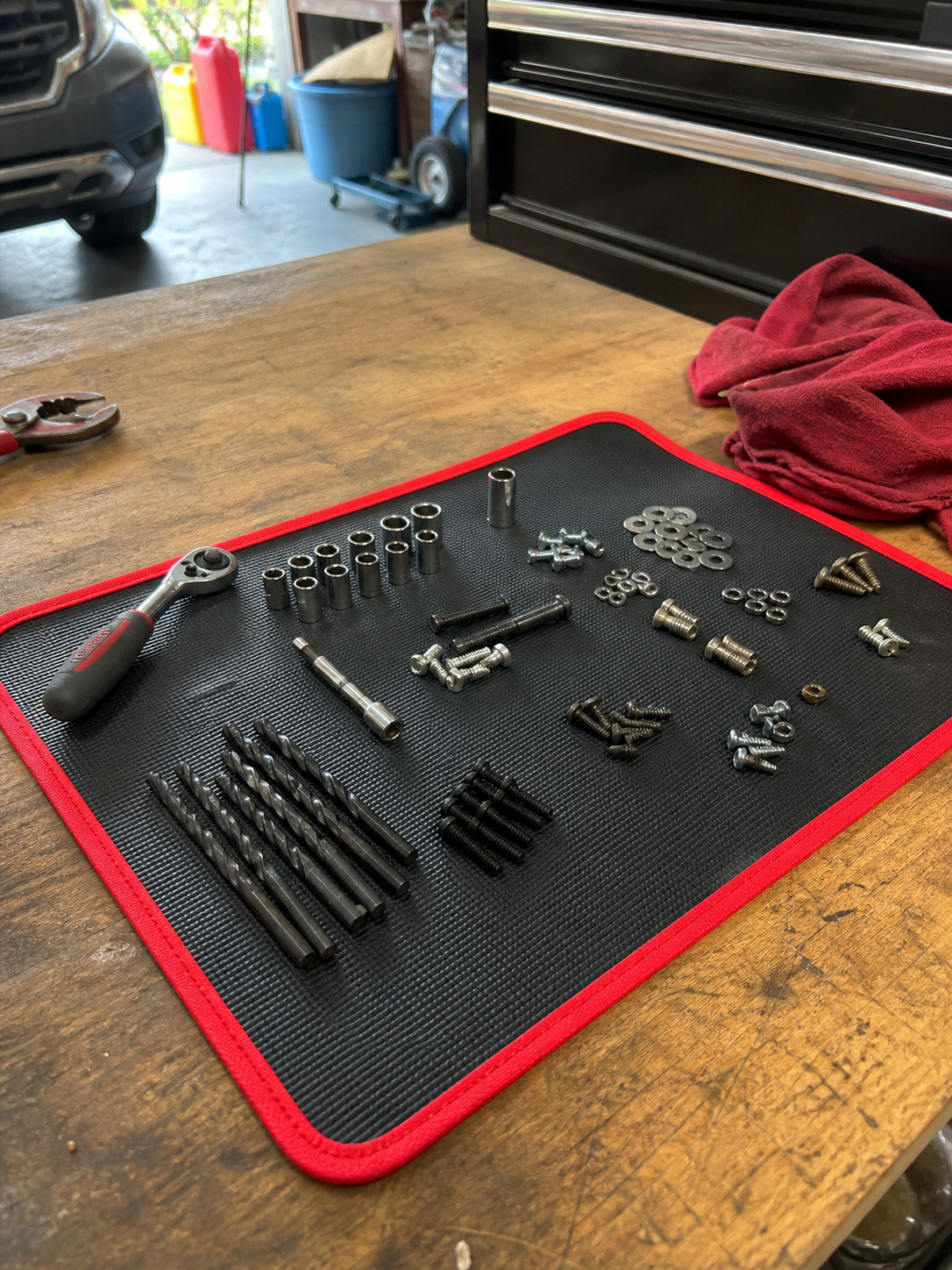 Customer review photo showing small hardware organized on the mat on a workbench.
