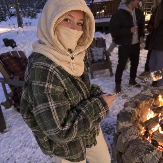 Customer by fire pit wearing cream fleece hood