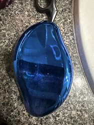 Blue crystal hair eraser on a bathroom counter near sink