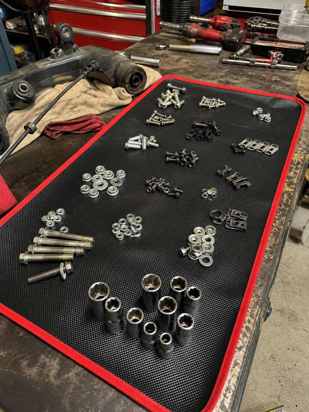 Customer review photo showing grouped brake hardware on the magnetic tool mat.