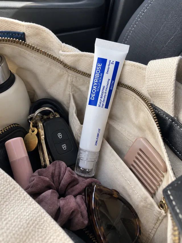 Compact scalp serum tube stored in a handbag for travel