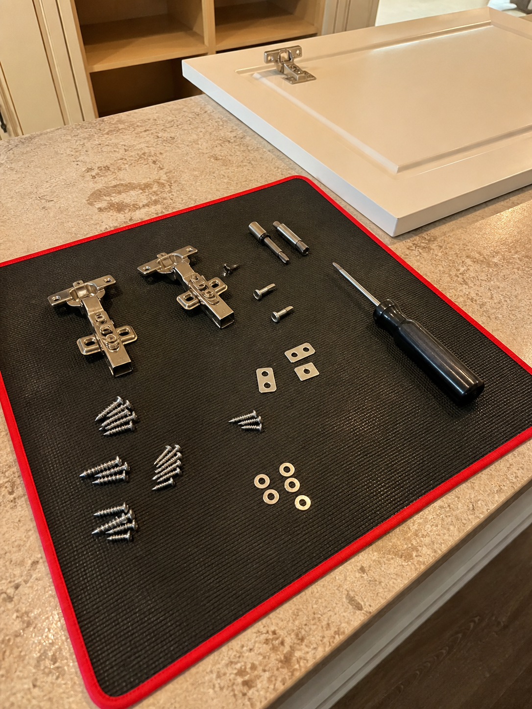 Customer review photo showing cabinet hardware sorted on the magnetic mat.