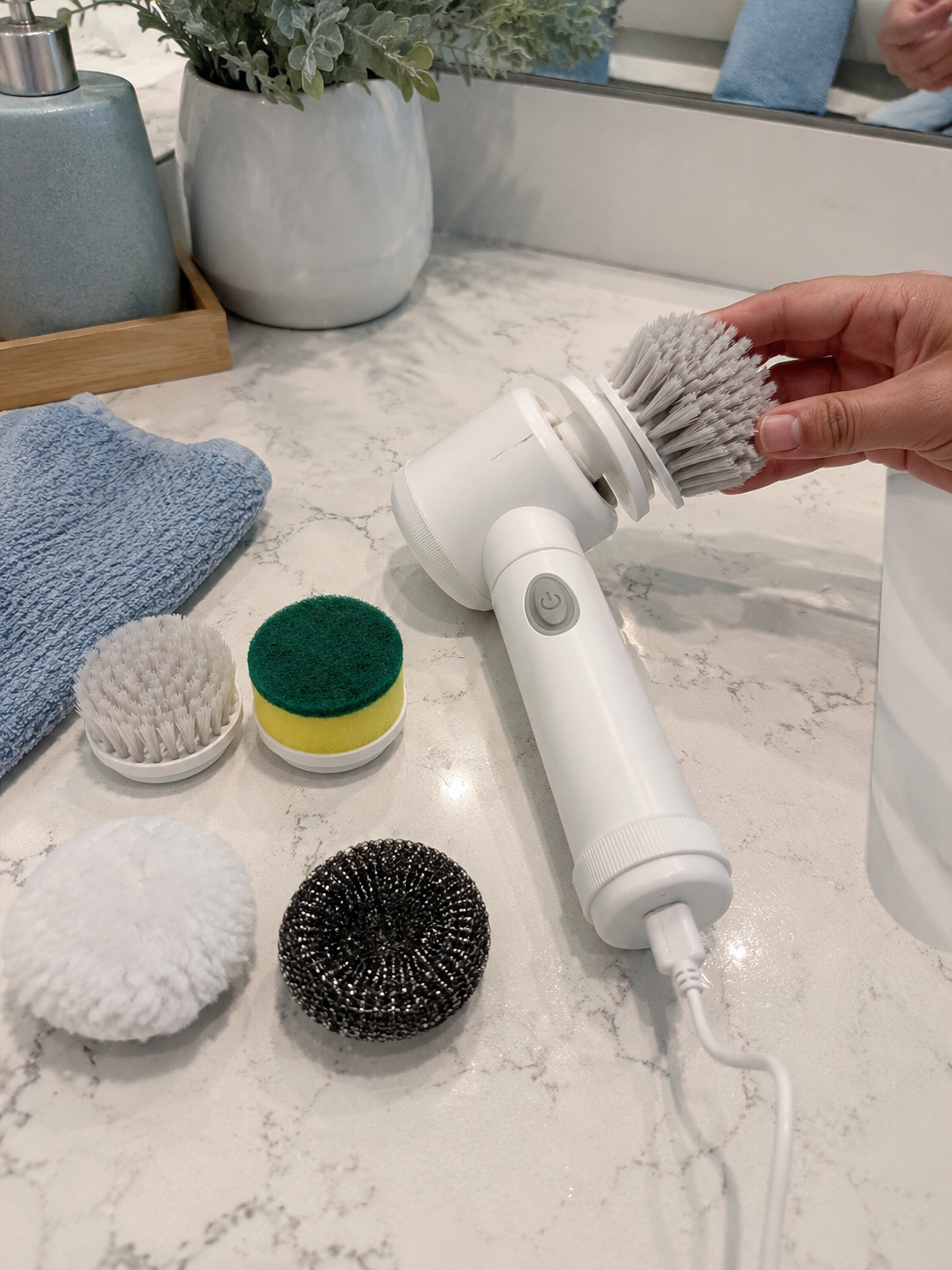 Customer photo of electric spin scrubber with brush head being replaced while charging.