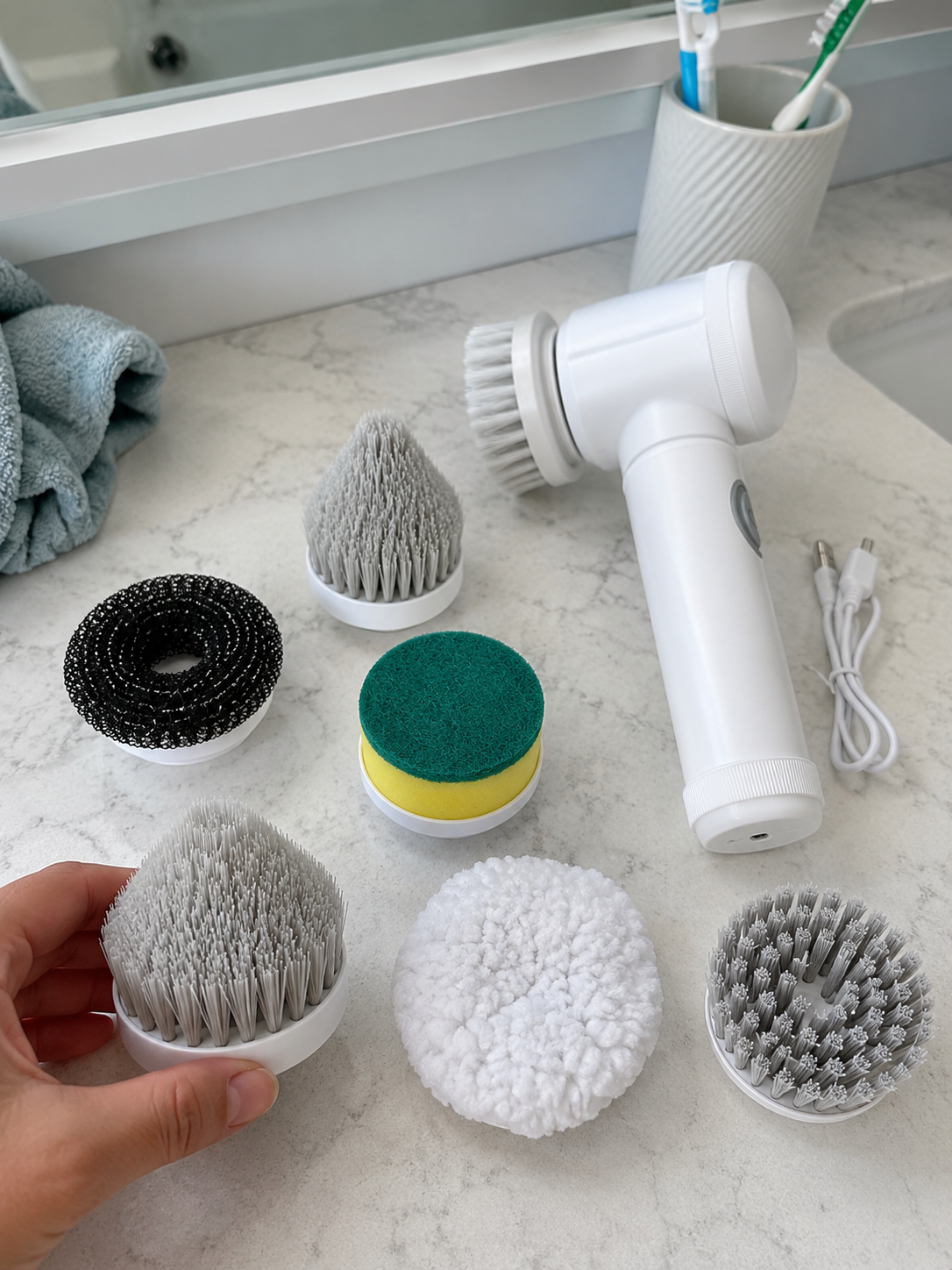 Customer photo of electric spin scrubber with six brush heads and charging cable.