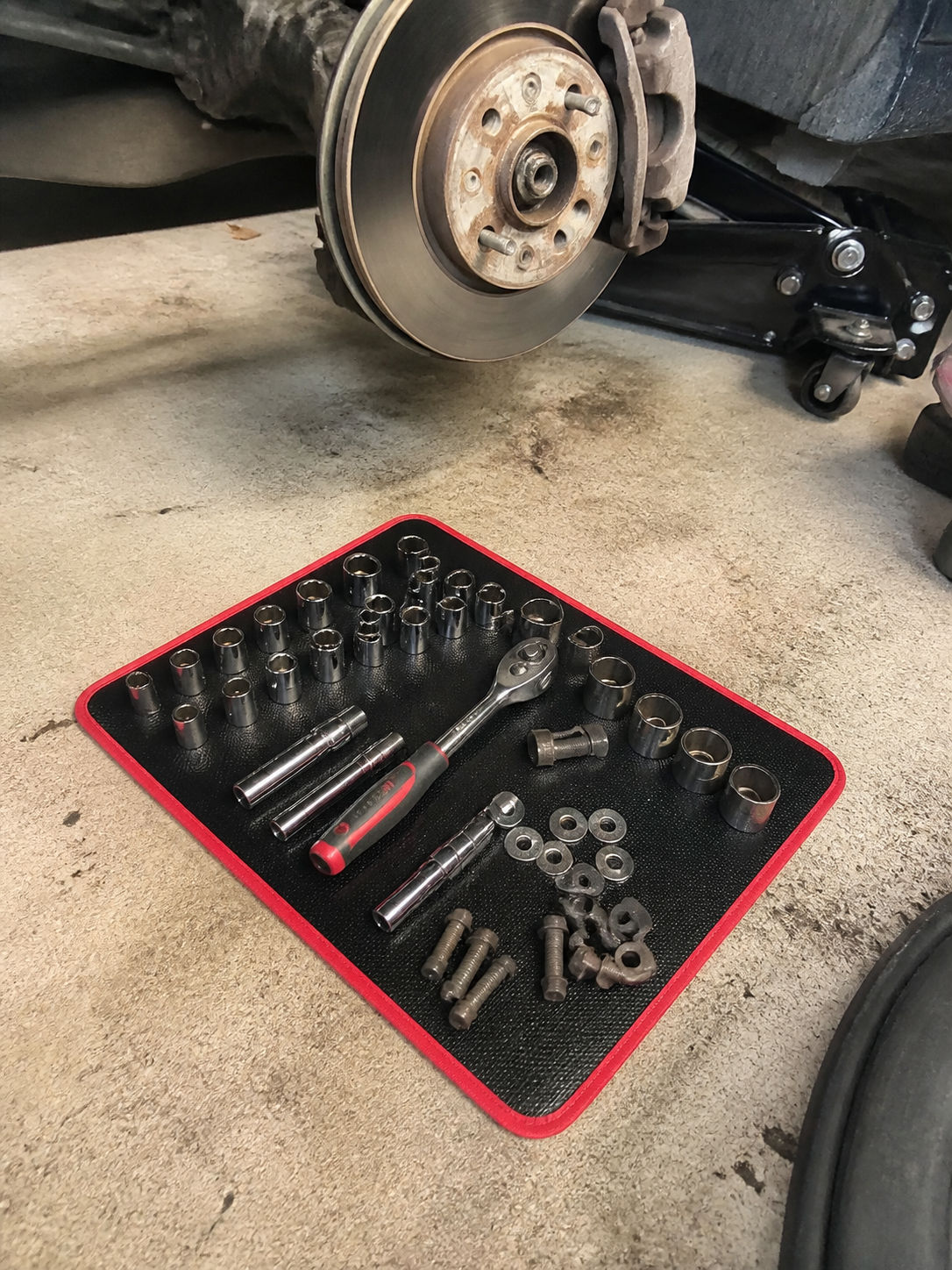 Customer review photo showing sockets and brake repair parts organized on the mat.