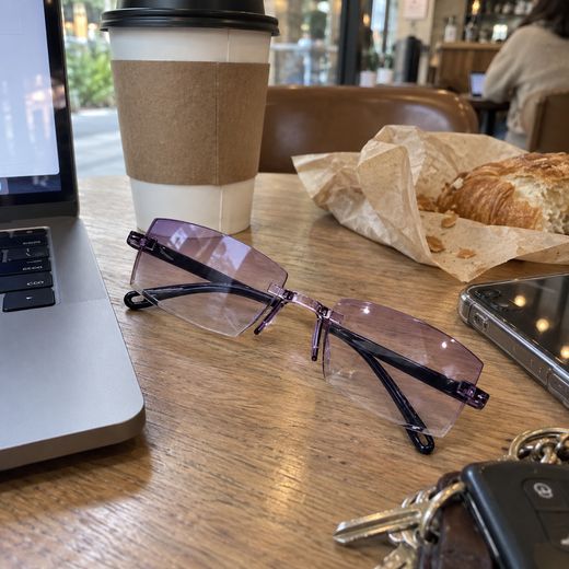 Purple smart zoom glasses at cafe beside laptop and coffee