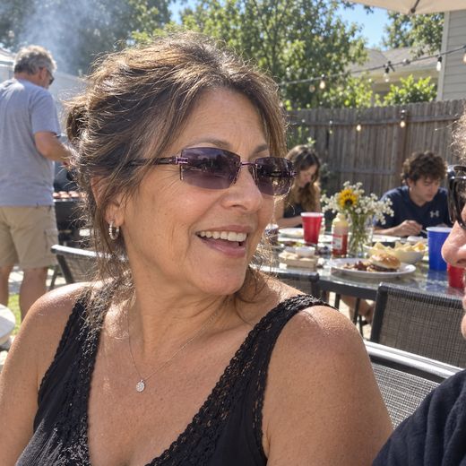 Woman outdoors at family barbecue wearing purple smart zoom glasses